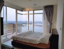 Spacious bedroom with large windows and panoramic city view