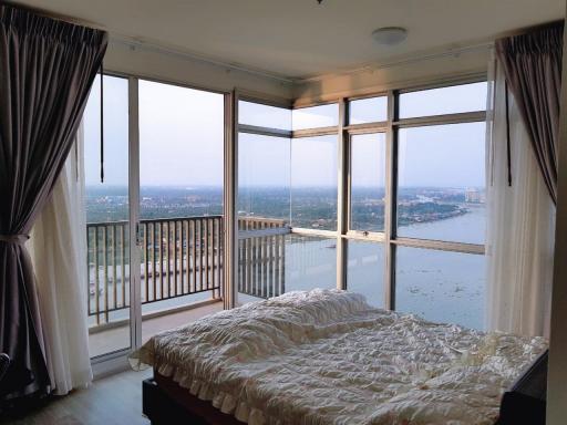 Spacious bedroom with panoramic windows overlooking the waterfront