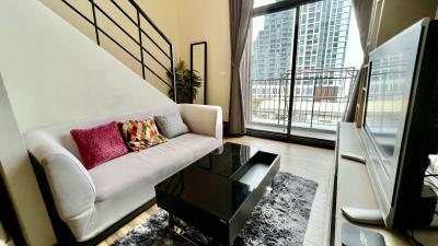 Modern living room interior with sofa, TV, and city view through large windows