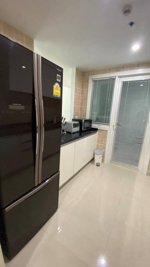 Modern kitchen with stainless steel appliances and tiled flooring