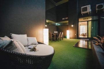 Spacious and modern living room with stylish dark walls and green carpet