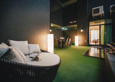 Spacious and modern living room with stylish dark walls and green carpet