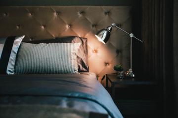 Elegant bedroom interior with tufted headboard and stylish bedside lighting