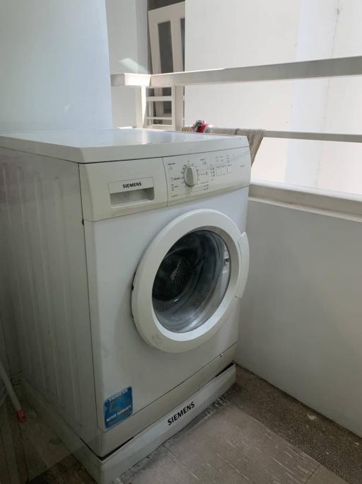 Siemens front-loading washing machine in a small laundry area