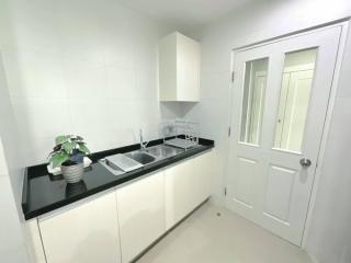 Modern kitchen with white cabinetry and black countertops