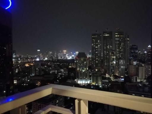 Night view from a high-rise apartment balcony overlooking the city skyline
