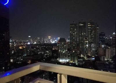 Night view from a high-rise apartment balcony overlooking the city skyline