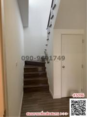 Wooden staircase inside a home with light-colored walls