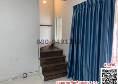 Bright bedroom with blue curtains and wooden steps leading to a platform