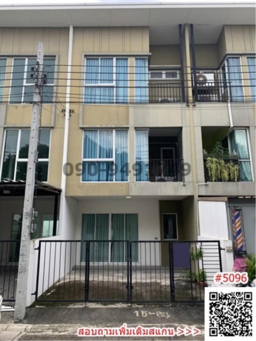 Three-story residential building with balconies and blue window accents