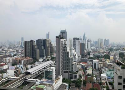 Expansive cityscape view from a high-rise building balcony showing numerous skyscrapers and buildings