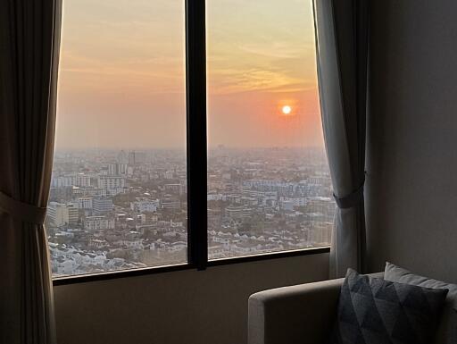 Sunset view from high-rise apartment bedroom with large windows