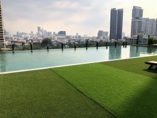 Rooftop pool with artificial grass and skyline view