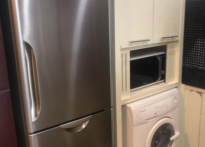 Modern kitchen with stainless steel refrigerator and built-in washing machine