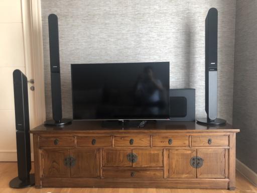 Modern living room with a large flat-screen television and surround sound speakers