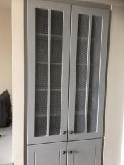 Modern built-in wardrobe with decorative mesh panels in a living space