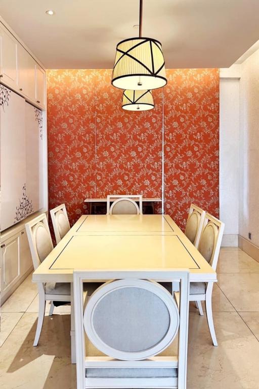 Bright dining room with a large table and orange floral wallpaper