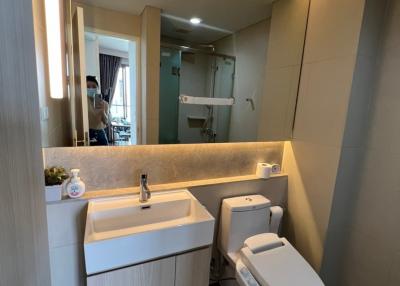 Modern bathroom with vanity, mirror, and toilet in a residential home