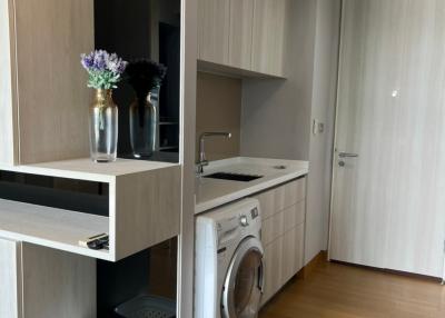 Modern home laundry room with washing machine and storage cabinets