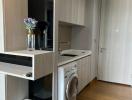 Modern home laundry room with washing machine and storage cabinets