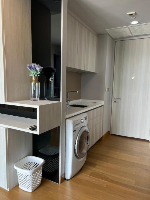 Modern home laundry room with washing machine and storage cabinets