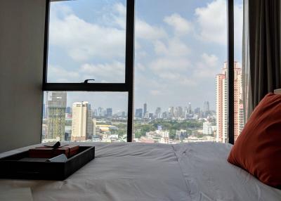 Cozy bedroom with a city view through a large window