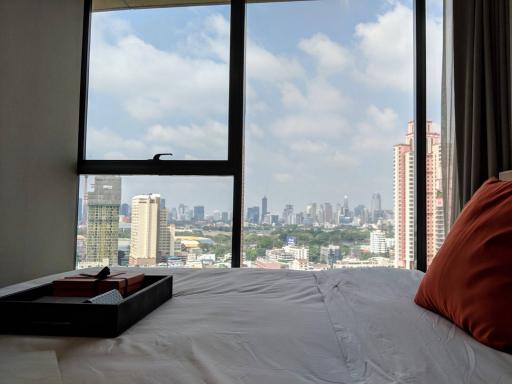 Cozy bedroom with a city view through a large window