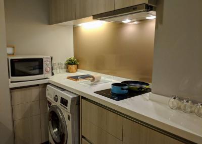 Modern compact kitchen with built-in appliances and white countertops