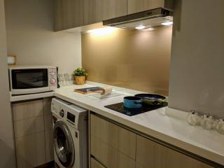 Modern compact kitchen with built-in appliances and white countertops