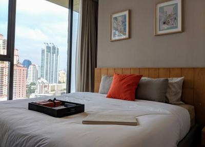 Modern bedroom with city view through large window