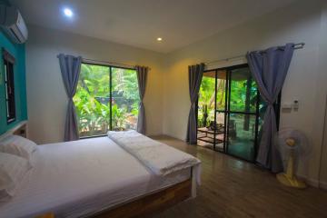 Spacious bedroom with large windows and garden view