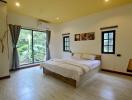 Spacious bedroom with modern furnishings and ample natural light