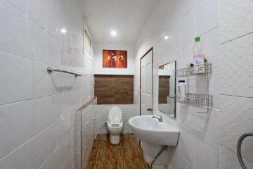 Modern bathroom with white tiles and wooden floor