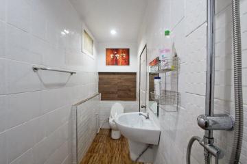 Modern clean bathroom with white tiles and wooden accents