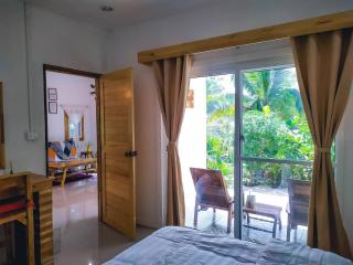 Bright bedroom with open French doors to garden