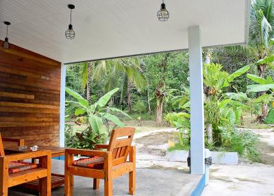 Spacious patio with wooden furniture and natural surroundings