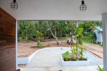 Spacious covered porch with a view of a green tropical garden