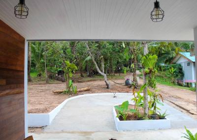 Spacious covered porch with a view of a green tropical garden