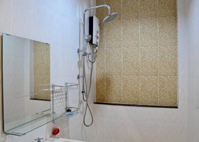 Modern bathroom shower with glass shelf and beige tiles