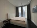 Modern bedroom with a large window and city skyline view