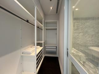 Spacious walk-in closet with shelving units and sliding glass door