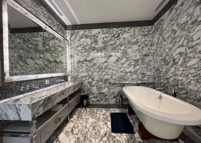 Luxurious bathroom with marble walls and flooring, featuring a freestanding bathtub