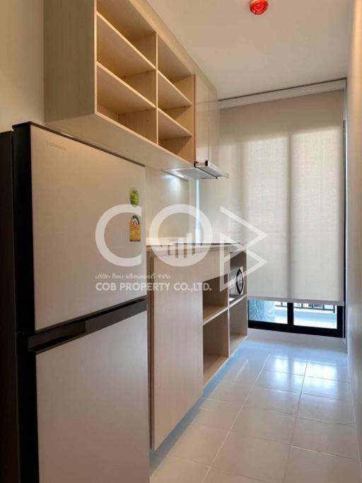 Compact modern kitchen with refrigerator and built-in shelves