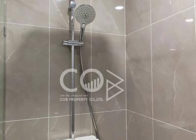 Modern shower with adjustable head and large wall-mounted overhead shower in a tiled bathroom