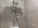 Modern shower with adjustable head and large wall-mounted overhead shower in a tiled bathroom