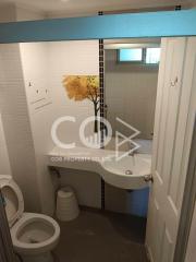 Compact bathroom with white tiling and a shower area