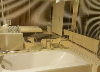 Modern bathroom with bathtub and window blinds