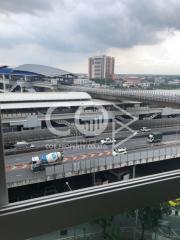 Urban view from a balcony showing a busy expressway and city buildings