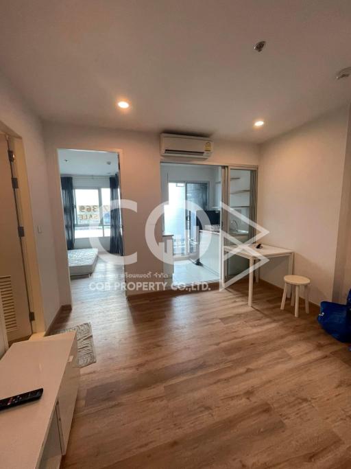 Minimalist bedroom with wooden flooring, ample natural light, and balcony access