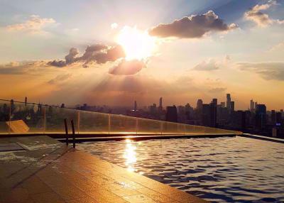 Rooftop swimming pool with sunset and city skyline view